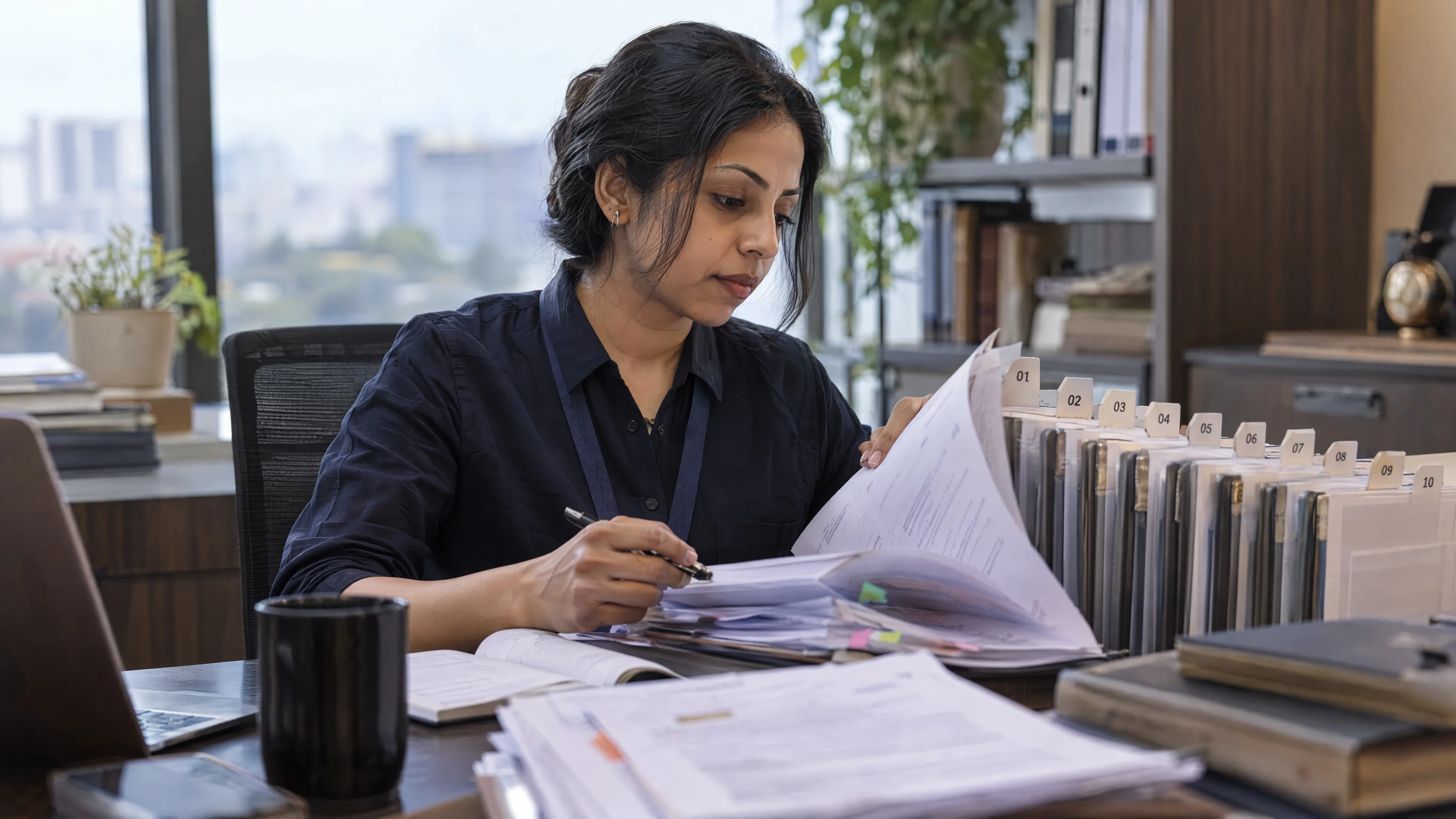 Reviewer tracing a paper record through numbered document tabs.
