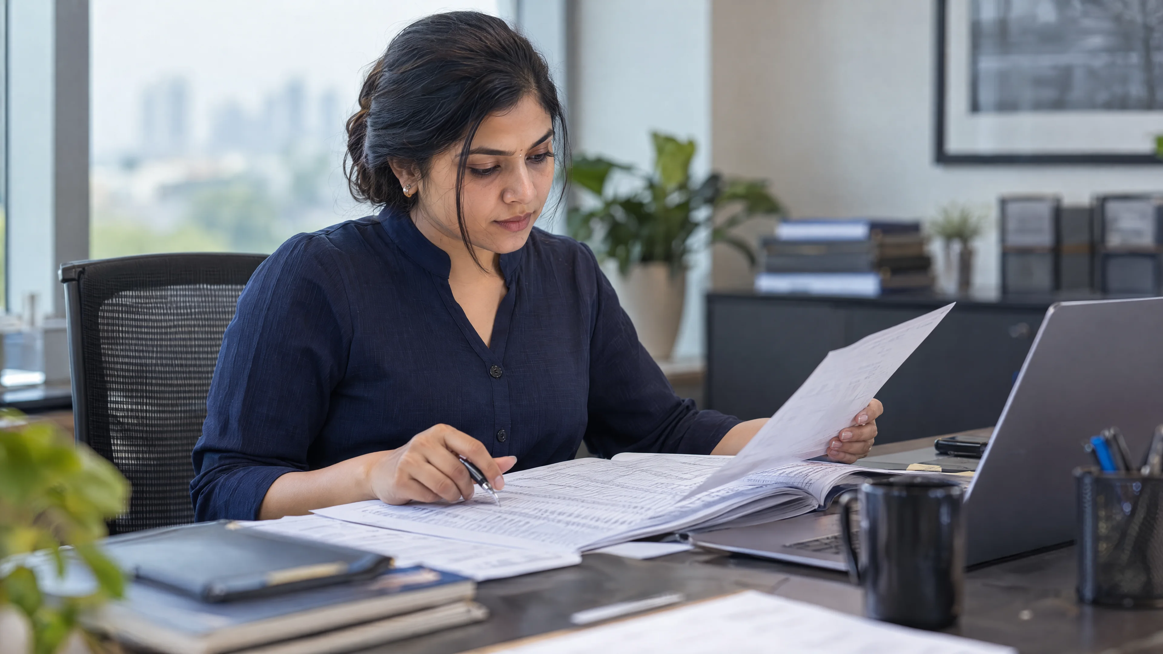 Quality analyst comparing a source register with a reconciled report.