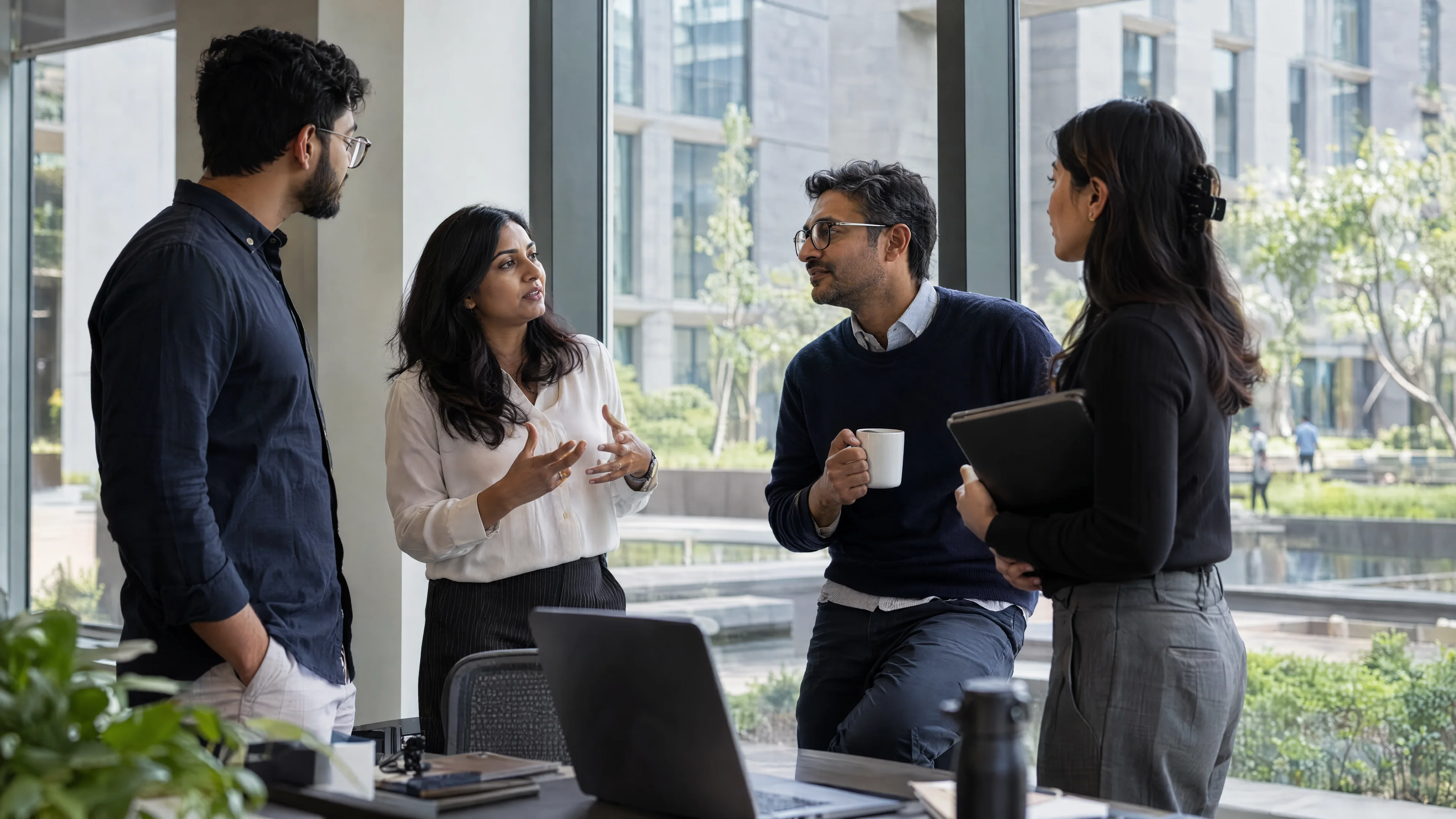 Business and engineering colleagues discussing a project beside office windows.
