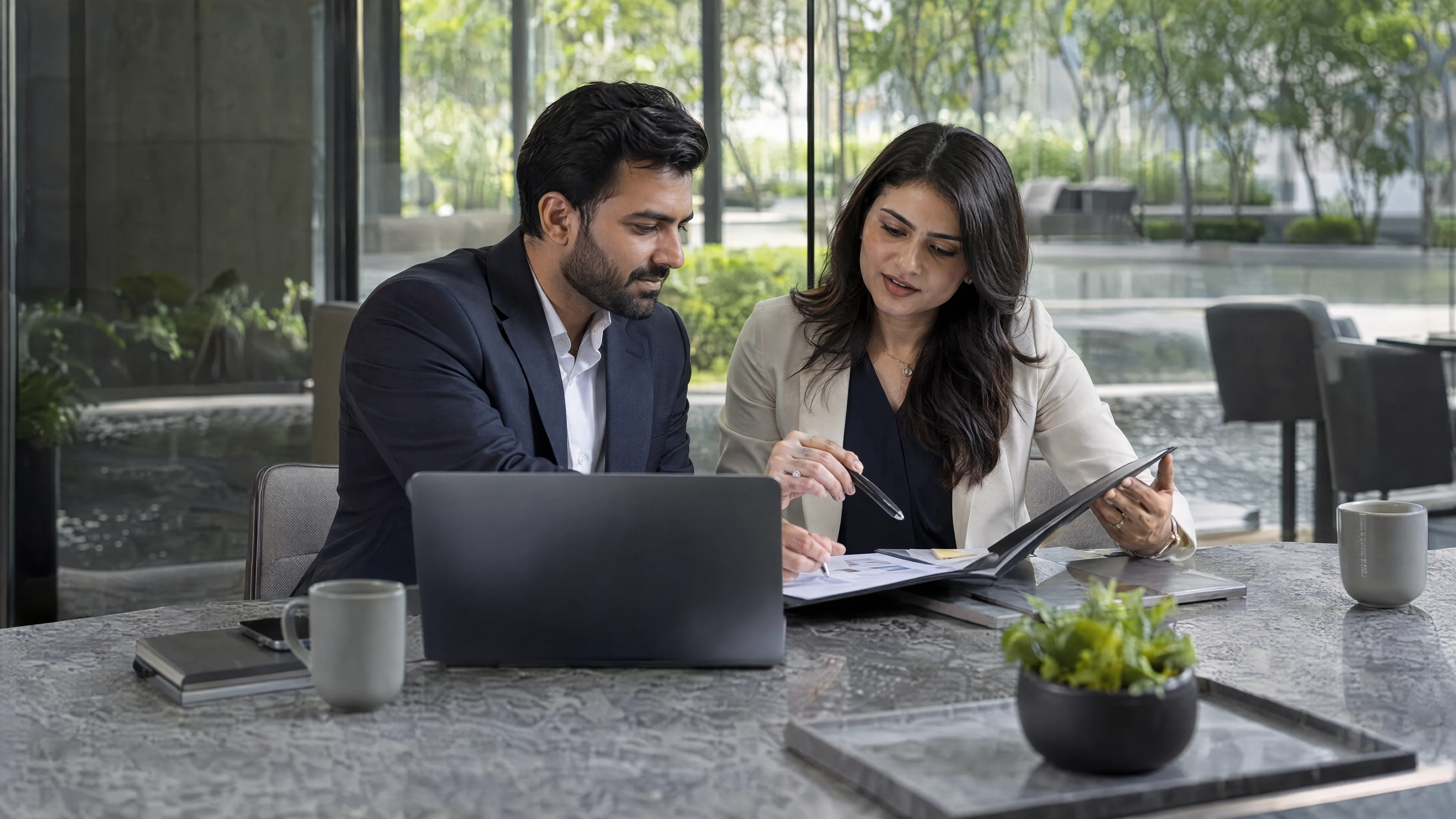 Business specialists reviewing a project folder in a meeting room.